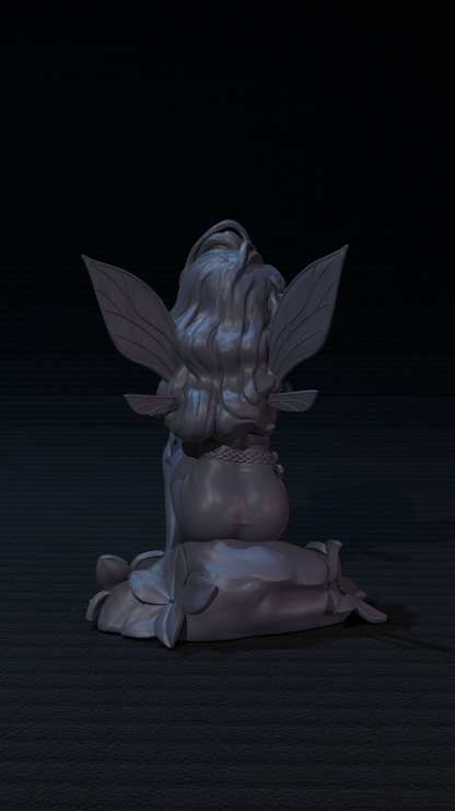 a statue of a fairy sitting on the ground