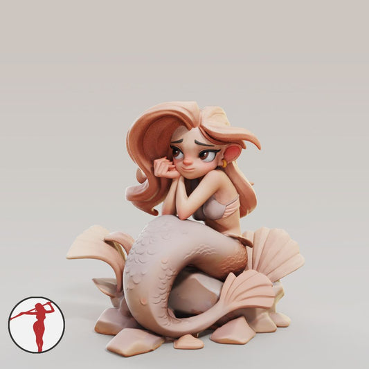 a figurine of a mermaid sitting on a rock