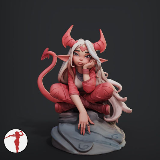 a statue of a demon girl sitting on a rock